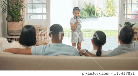 Portrait, performance and child singing with microphone in family home for creativity, talent and show. People, group and young girl in lounge for karaoke, reunion and summer holiday in countryside 115437851