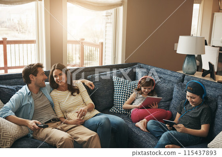 Family, children and parents on couch, watching tv or streaming on tablet with bonding in living room. Mother, father and kids with electronics, popcorn or movies to relax with show on sofa at house 115437893