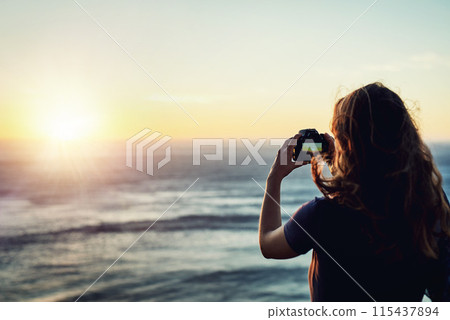 Beach, sunset or girl with camera in nature for photography, memory or scenic capture on summer, trip or vacation. Lens, sea or woman back with digital photo of ocean, water or sunrise travel moment 115437894