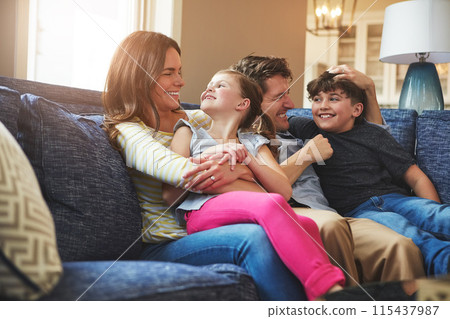 Hugging, happy and children with parents on sofa in home relaxing with care, fun and love together. Laughing, bonding and kids embracing with mother and father in living room at family house. 115437987