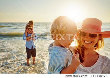 Happy mother, family and beach with hug for bonding, outdoor holiday or weekend in sunset or nature. Mom, child and little boy with smile for embrace, love or care in sunshine by ocean coast or sea 115438378