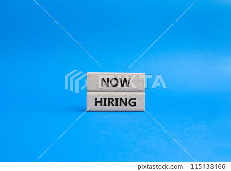 Now Hiring symbol. Concept word Now Hiring on wooden blocks. Beautiful blue background. Business and Now Hiring concept. Copy space 115438466