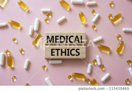 Medical Ethics symbol. Concept word Medical Ethics on wooden blocks. Beautiful pink background with pills. Medicine and Medical Ethics concept. Copy space 115438469