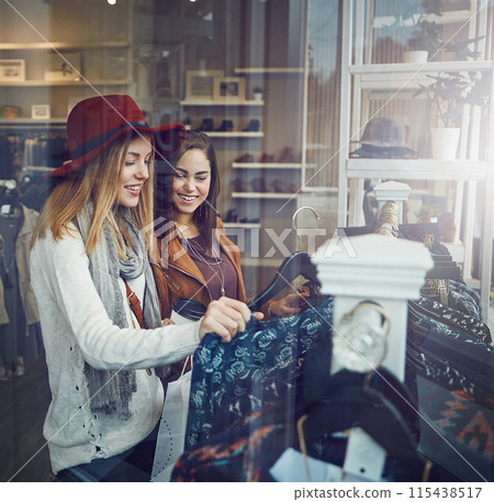 Shopping, bonding and girl friends by clothes in retail mall for discount, sale or promotion. Style, window and young women buying designer outfit on rack at luxury fashion boutique or store. Shopping, bonding and girl friends by clothes in retail mall for discount, sale or promotion. Style, window and young women buying designer outfit on rack at luxury fashion boutique or store. 115438517