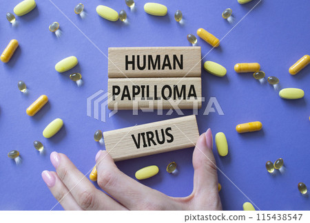 Human Papilloma Virus symbol. Concept word Human Papilloma Virus on wooden blocks. Doctor hand. Beautiful pink background with pills. Medicine and Human Papilloma Virus concept. Copy space 115438547