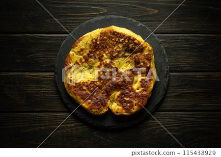 Round fried homemade pancake on black dessert sorting board. Delicious snack serving concept 115438929