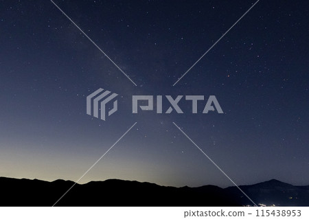 The Milky Way, starry sky, Mt. Buko and other mountains, and light pollution in the direction of Tokyo as seen from the observation deck at the top of Mt. Minoyama, located in Chichibu City and Minano Town, Saitama Prefecture. 115438953