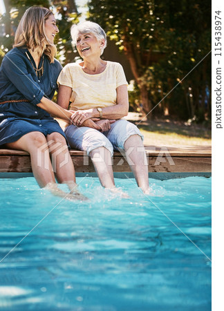 Mother, daughter and happiness by swimming pool for laughing, holding hands or relax in garden. Senior mom, woman and together in outdoor with smile for bonding, family or love and feet in water Mother, daughter and happiness by swimming pool for laughing, holding hands or relax in garden. Senior mom, woman and together in outdoor with smile for bonding, family or love and feet in water 115438974