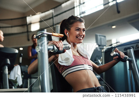 Girl, workout and chest press in gym for fitness, power and muscle development with towel, music or smile. Athlete, training and exercise in sports club for health, wellness or results with earphones 115438991