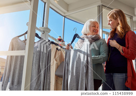 Mature woman, retail clothes and shopping choice, decision and brand fashion sale for luxury wardrobe at boutique. Smile, people and customer, designer product and quality fabric at supplier store Mature woman, retail clothes and shopping choice, decision and brand fashion sale for luxury wardrobe at boutique. Smile, people and customer, designer product and quality fabric at supplier store 115438999