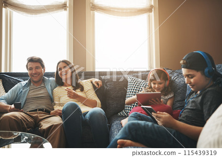 Family, children and parents with watching tv, happy or streaming on tablet with bonding in living room. Mother, dad and kids with electronics, popcorn or comedy to relax with show on sofa at house Family, children and parents with watching tv, happy or streaming on tablet with bonding in living room. Mother, dad and kids with electronics, popcorn or comedy to relax with show on sofa at house 115439319