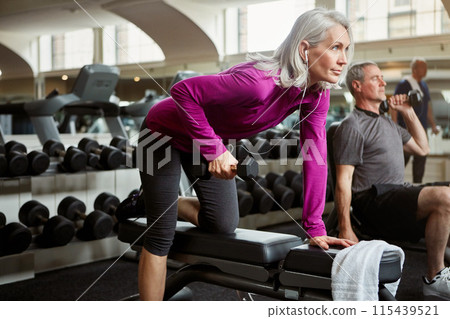 Workout, weights and senior woman in gym for fitness, training and cardio exercise listen to music. Retirement, sports and person with dumbbells for wellness, muscle strength and mobility for health Workout, weights and senior woman in gym for fitness, training and cardio exercise listen to music. Retirement, sports and person with dumbbells for wellness, muscle strength and mobility for health 115439521