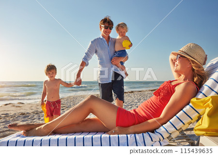 Chair, relax or children with parents at beach on holiday vacation or happy family weekend together. Father, fun mother or kids siblings at sea for bonding or playing in nature in Spain in summer 115439635