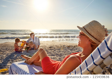 Chair, sunset or kids with woman at beach on holiday vacation or weekend together with dad or family. Father, calm mother or children siblings at sea for bonding or break in nature in Spain in summer Chair, sunset or kids with woman at beach on holiday vacation or weekend together with dad or family. Father, calm mother or children siblings at sea for bonding or break in nature in Spain in summer 115439636