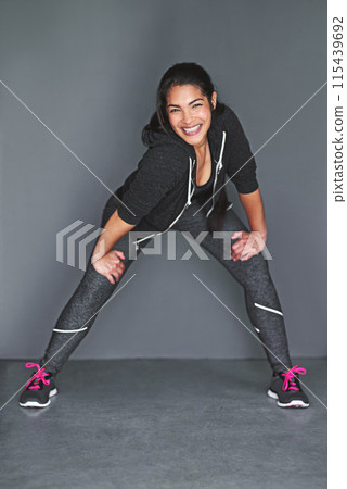 Gym, stretch and woman for fitness, flexibility and portrait for wellness in studio. Legs, sports and exercise for training or routine and balance, muscle and recovery or warm up for healthy person 115439692