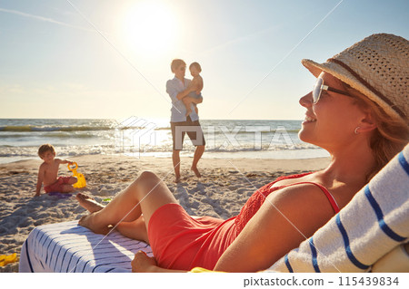 Woman, relax and blue sky on beach chair with family together, adventure and bonding in summer holiday. Happy, mother and father or child by ocean outdoor, travel and tropical vacation in Greece 115439834