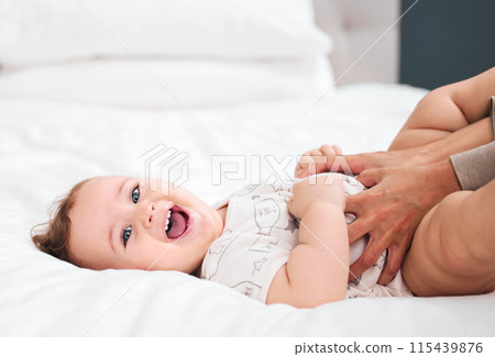 Love, portrait and happy baby with mother on a bed for fun, bonding and playing tickle games in their home together. Smile, face and excited kid with parent in a bedroom for comfort, care or support 115439876