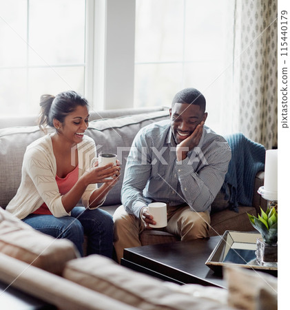 Couple, coffee and relaxing on sofa in morning for conversation or talk in living room. Discussion, woman and man with smile, happy and married with tea for day plan or romantic date in summer home. 115440179