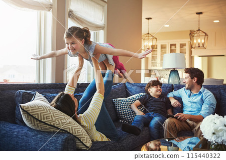 Airplane, playing and children with parents on sofa in home relaxing with care, happiness and love together. Smile, bonding and girl kid with flying role play with mom, brother and dad in living room 115440322