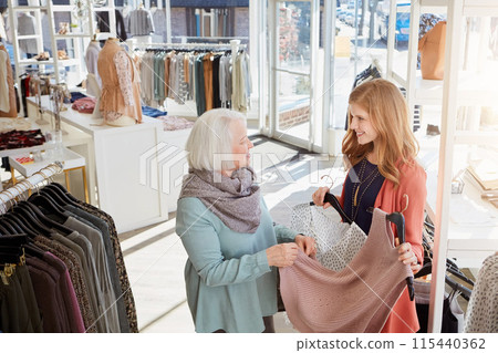 Clothes, shopping or talking with mother and daughter in boutique, mall or store for fashion together. Family, retail or smile with happy senior parent and woman customer for outlet decision Clothes, shopping or talking with mother and daughter in boutique, mall or store for fashion together. Family, retail or smile with happy senior parent and woman customer for outlet decision 115440362