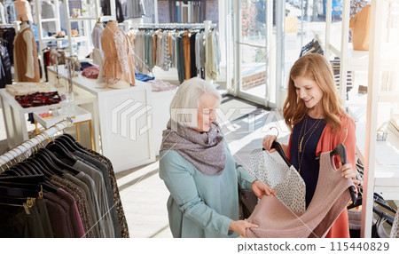 Clothes, retail or shopping mall with mother and daughter in boutique or store for fashion together. Choice, family or smile with happy senior parent and woman customer in clothing outlet from above 115440829