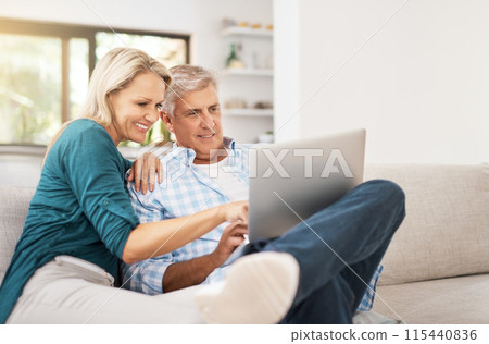 Couple, couch and laptop with smile in home, streaming and relax in living room for movies. Internet, computer and point for website for video with married people, calm and lounge with technology pc 115440836