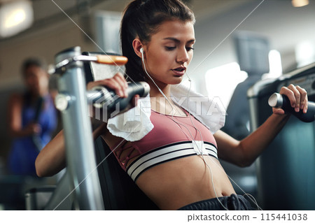 Girl, workout and chest press in gym for fitness, power and muscle development with earphones or towel. Athlete, training and exercise in sports club for wellness, health and results with commitment 115441038