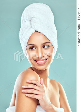 Woman, thinking and towel on head in studio for shower, hygiene and smile for cleaning. Model girl, happy and idea for wellness or grooming in morning with routine and skincare by blue background 115441402