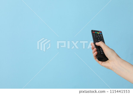 A female hand holds a remote control A female hand holds a remote control 115441553