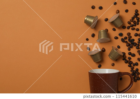Cup, coffee capsules and beans on brown background, space for text Cup, coffee capsules and beans on brown background, space for text 115441610