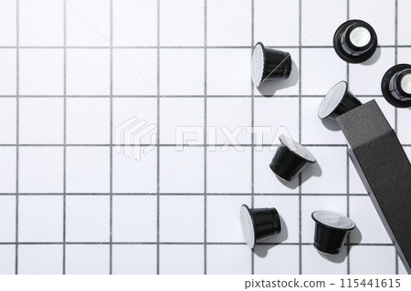 Black coffee capsules and box on light background, space for text Black coffee capsules and box on light background, space for text 115441615