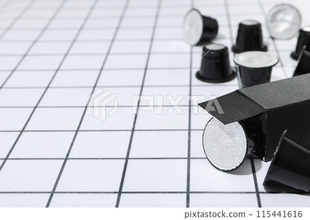 Black coffee capsules and box on light background, space for text Black coffee capsules and box on light background, space for text 115441616