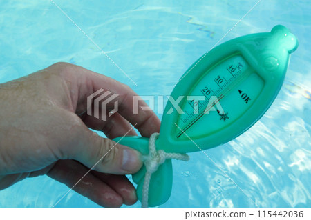 a man hand checks the temperature with a thermometer on a sunny day 115442036