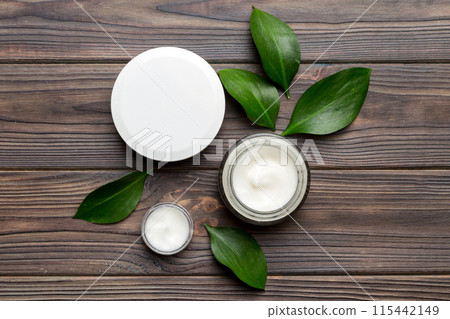 Organic cosmetic products with green leaves on wooden background. Flat lay 115442149