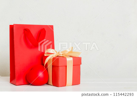 Shopping bag with gift box on colored background perspecrive view. Space for text holiday concept Shopping bag with gift box on colored background perspecrive view. Space for text holiday concept 115442293