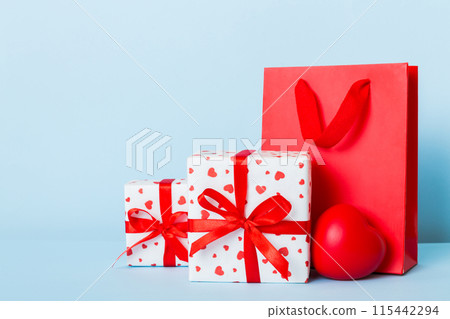 Shopping bag with gift box on colored background perspecrive view. Space for text holiday concept Shopping bag with gift box on colored background perspecrive view. Space for text holiday concept 115442294