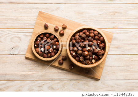 Wooden bowl full of hazelnuts on table background. Healthy eating concept. Super foods 115442353