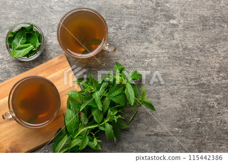 Cup of mint tea on table background. Green tea with fresh mint top view with copy space 115442386