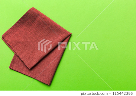 top view with red empty kitchen napkin isolated on table background. Folded cloth for mockup with copy space, Flat lay. Minimal style top view with red empty kitchen napkin isolated on table background. Folded cloth for mockup with copy space, Flat lay. Minimal style 115442396