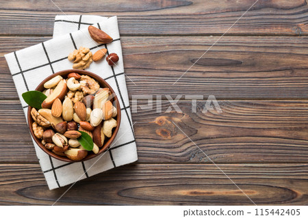mixed nuts in bowl. Mix of various nuts on colored background. pistachios, cashews, walnuts, hazelnuts, peanuts and brazil nuts mixed nuts in bowl. Mix of various nuts on colored background. pistachios, cashews, walnuts, hazelnuts, peanuts and brazil nuts 115442405