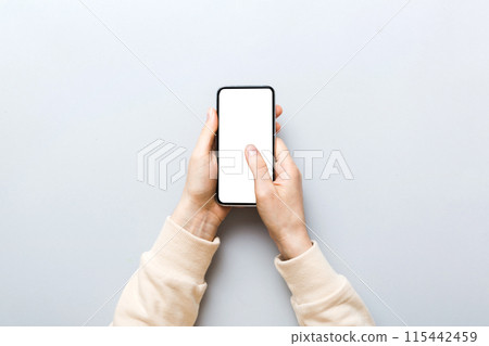Top view of woman hands holding smart phone with blank copy space screen for your text message or information content. woman hand using phone white screen on top view Top view of woman hands holding smart phone with blank copy space screen for your text message or information content. woman hand using phone white screen on top view 115442459