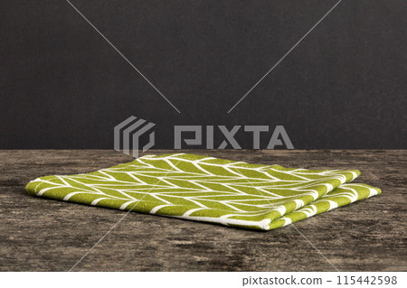 top view with green kitchen napkin isolated on table background. Folded cloth for mockup with copy space, Flat lay. Minimal style 115442598