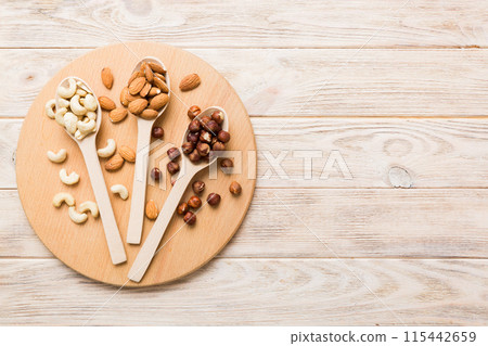 Assortment of nuts in wooden spoon on colored table. Cashew, hazelnuts, walnuts, almonds. Mix of nuts Top view with copy space Assortment of nuts in wooden spoon on colored table. Cashew, hazelnuts, walnuts, almonds. Mix of nuts Top view with copy space 115442659