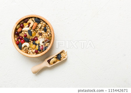 Cooking a wholesome breakfast. Granola with Various dried fruits and nuts in a bowl. The concept of a healthy dessert. Flat lay, top view with copy space 115442671
