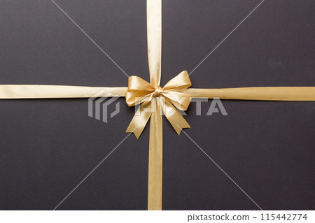 Top view of gold ribbon rolled and yellow bow isolated on colored background. Flat lay with copy space Top view of gold ribbon rolled and yellow bow isolated on colored background. Flat lay with copy space 115442774