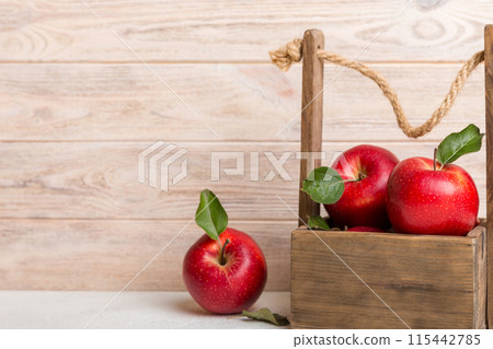Ripe red apples in wooden box. On a white wooden background Ripe red apples in wooden box. On a white wooden background 115442785