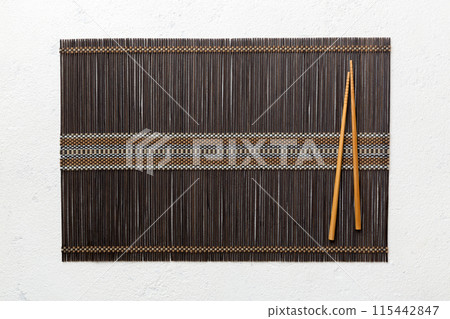 Two chopsticks and bamboo mat on cement background. Top view, copy space Two chopsticks and bamboo mat on cement background. Top view, copy space 115442847