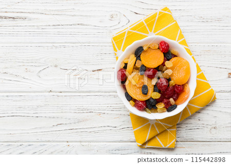 Bowl with different dried fruits on table background, top view. Healthy lifestyle with copy space 115442898