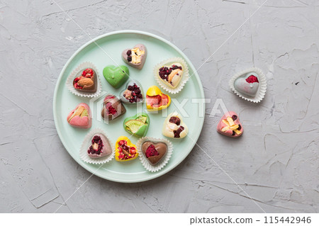 Plate with different chocolate on colored background. Assortment of fine chocolates top view vith copy space Health and obesity concept Plate with different chocolate on colored background. Assortment of fine chocolates top view vith copy space Health and obesity concept 115442946