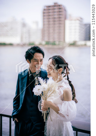 Bride and groom laughing by the river 115443029